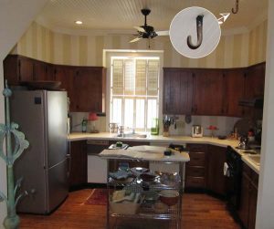 The kitchen had been remodeled in the ‘60s. The cabinetry not only darkened the room, but the upper cabinets were out of scale, making the space seem very bottom heavy. Note the infamous hook in the ceiling, which dates to the early days of the 20th century, when the building housed a sleigh and later, cars.