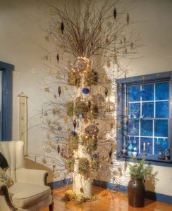 When Elaine bought four architectural columns that were removed from the Abraham Lincoln Hotel in Reading, she envisioned using one as a “tree” on which she could display the ornaments and other keepsakes she had collected on her travels. Floral designer Kerry Kegerise devised a way to attach branches to the tree. Initially, Elaine decorated it with seasonal items, but decided she liked her Christmas ornaments the most, so the theme remains in place on a year-round basis.