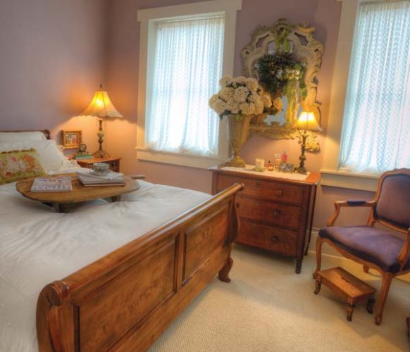 Antiques and an amethyst wall color provide for a comfy guest bedroom.