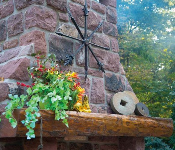 The mantel (also taken from the farm) is decorated with millstones and a metal sculpture that was created from pieces of an old iron fence.